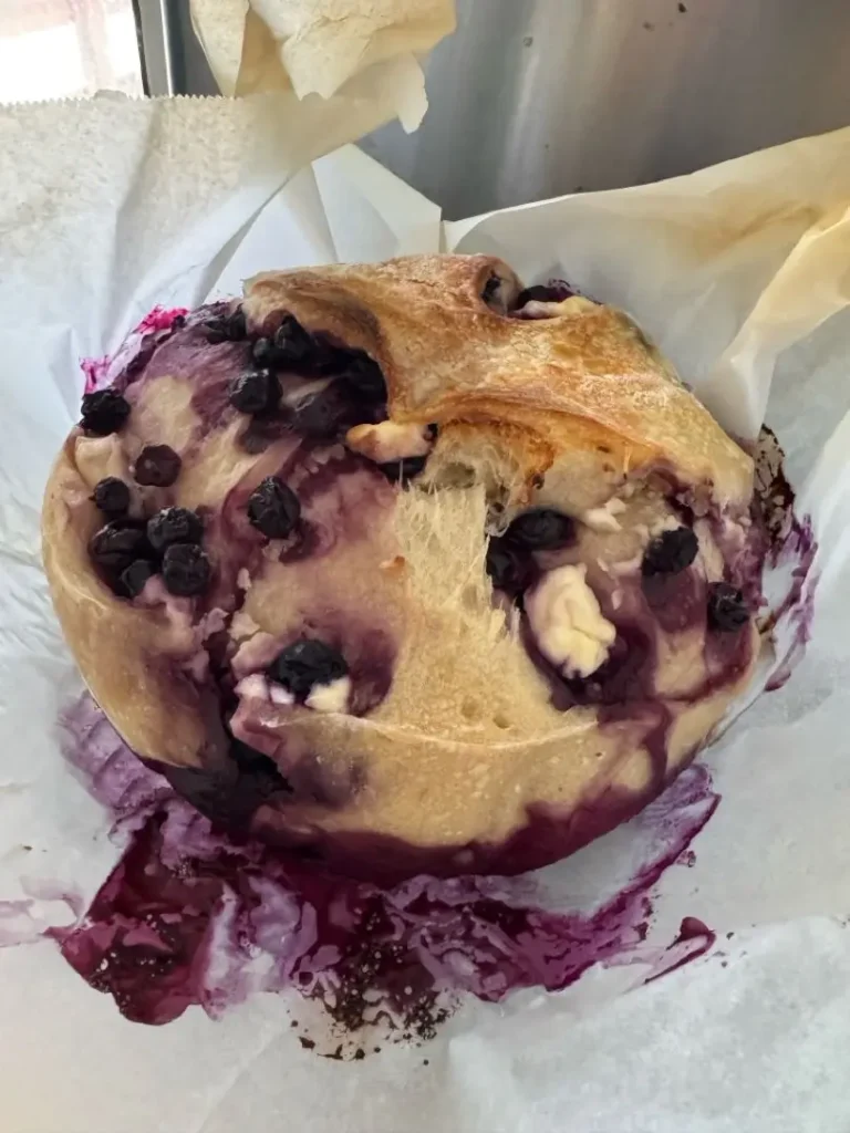 Sliced blueberry lemon sourdough bread with cream cheese filling showing purple berry swirls and fluffy texture