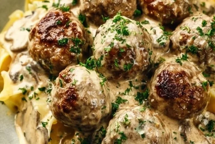 Swedish meatballs served in creamy mushroom sauce, garnished with parsley.