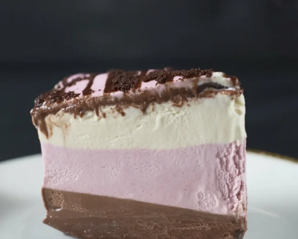 Vegan Neapolitan Cake with Coconut Cream, showcasing strawberry, vanilla, and chocolate layers.