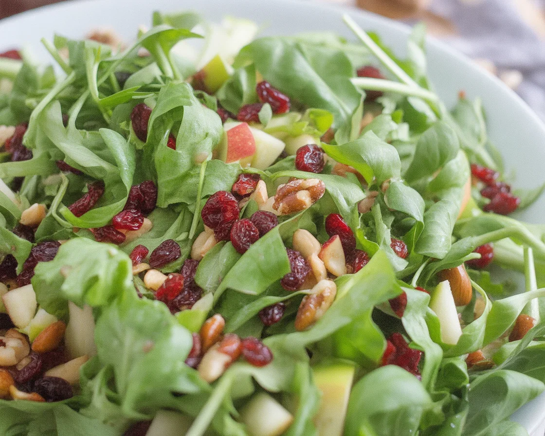 Colorful Autumn Chopped Salad with greens, apples, and cranberries topped with feta