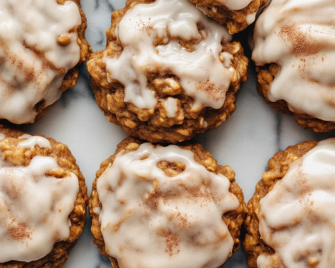 Delicious iced pumpkin oatmeal cookies topped with cinnamon glaze on a plate.