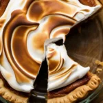 Delicious Bourbon Sweet Potato Pie topped with cream and spices, perfect for fall.