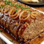 Savory meatloaf topped with caramelized onion gravy served on a plate