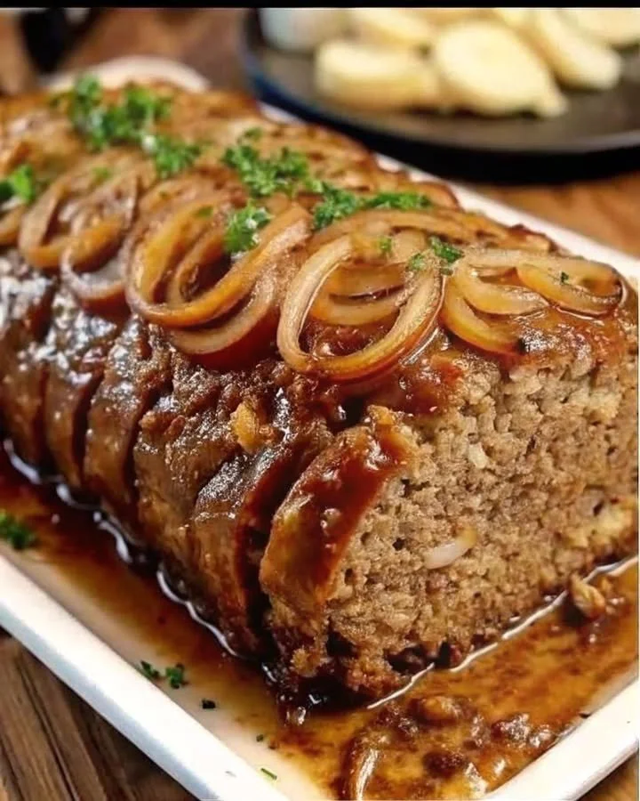 Savory meatloaf topped with caramelized onion gravy served on a plate