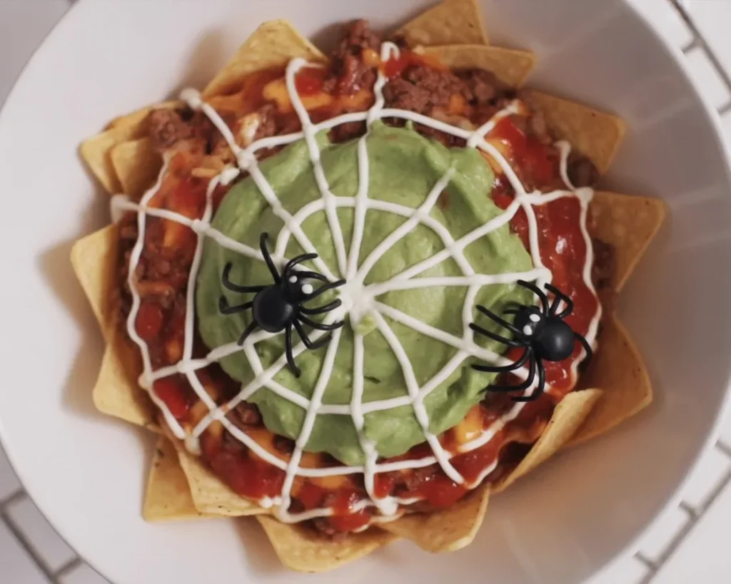 Delicious Halloween Nachos (version végétarienne) topped with guacamole and fresh salsa.