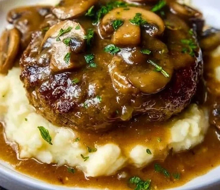 Savory beef patties served in creamy mushroom gravy on a plate