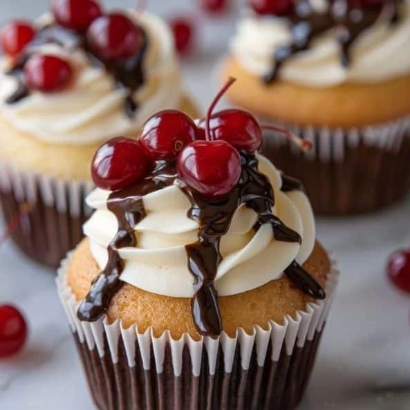 Boston Cream Pie Cupcakes topped with chocolate glaze and vanilla cream filling.