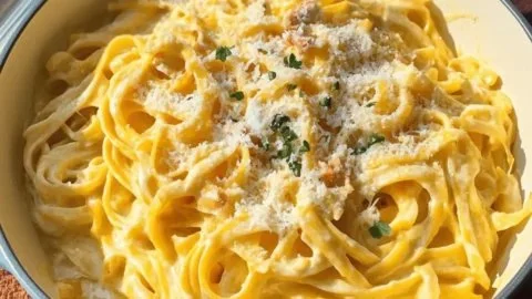 Creamy Pumpkin Alfredo pasta dish garnished with herbs and served in a bowl
