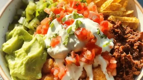 Delicious crispy tater tot taco bowl served in a colorful dish with toppings.