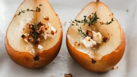 Delicious roasted pears garnished with goat cheese, hazelnuts, and thyme
