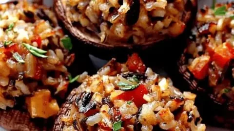Vegetarian wild rice stuffed mushrooms on a plate, ready to be served.