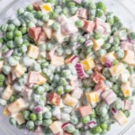 Classic Pea Salad with bacon, cheddar, and creamy dressing served in a bowl.
