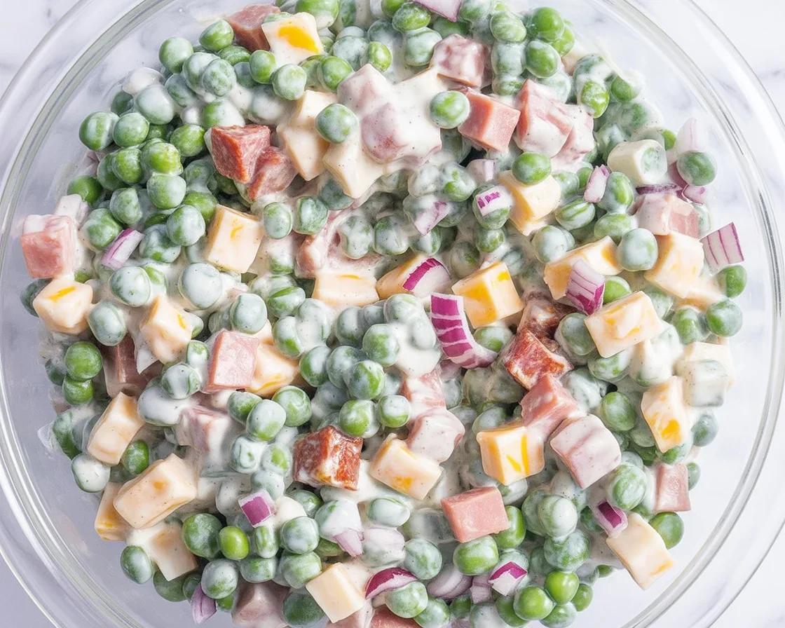 Classic Pea Salad with bacon, cheddar, and creamy dressing served in a bowl.