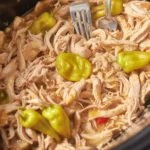 Delicious Crockpot Mississippi Chicken with ranch seasoning, gravy, and peppers.