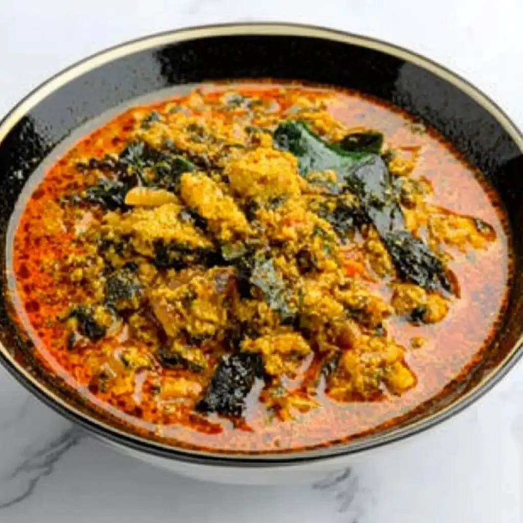 Bowl of delicious Egusi Soup garnished with spinach and spices