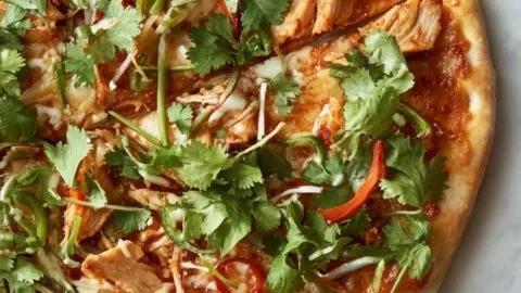 Fresh and flavorful Thai chicken pizza topped with herbs and spices.
