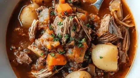 Delicious goose stew served in a rustic bowl, showcasing hearty ingredients.