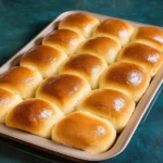Freshly baked homemade dinner rolls on a rustic table