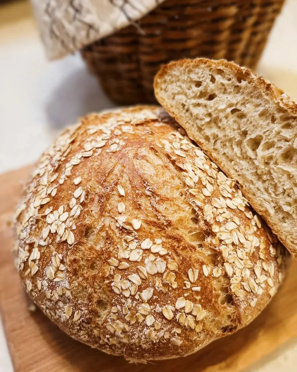 Freshly baked Honey Oat Sourdough Bread with a golden crust and oat topping.