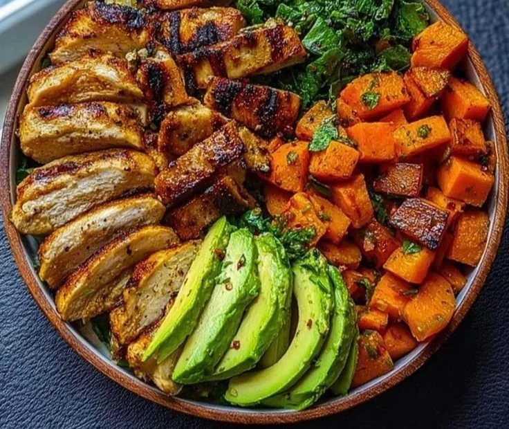 Delicious Loaded Grilled Chicken and Sweet Potato Power Bowl garnished with fresh herbs