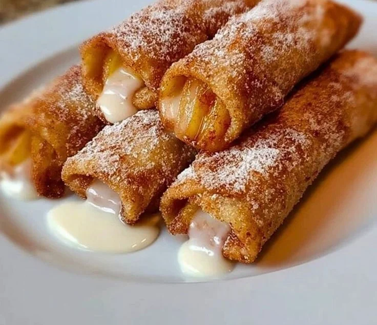 Crispy peach cobbler egg rolls served on a plate with dipping sauce