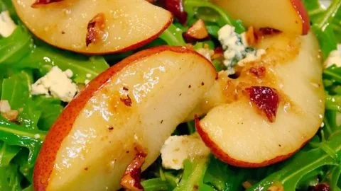 Savory roasted pear blue cheese arugula salad garnished with nuts
