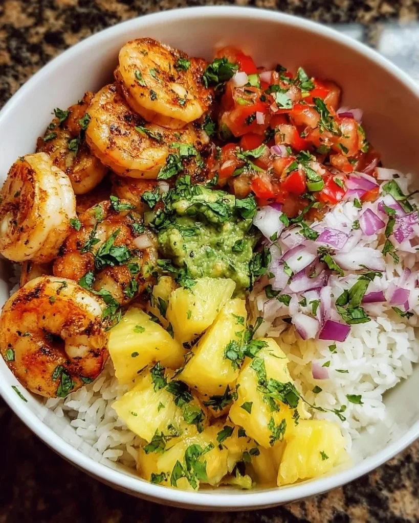 Shrimp rice bowl topped with pineapple salsa in a colorful presentation