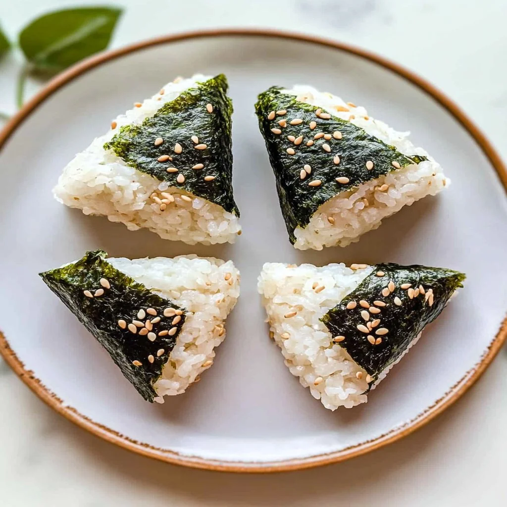 Delicious spicy tuna rice balls served on a plate garnished with herbs.