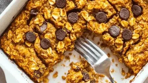 Warm pumpkin baked oatmeal in a bowl topped with nuts and spices