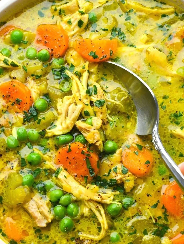 Bowl of anti-inflammatory turmeric chicken soup with fresh herbs and spices