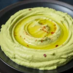 Creamy avocado hummus made with garlic, lime, and spices in a bowl.
