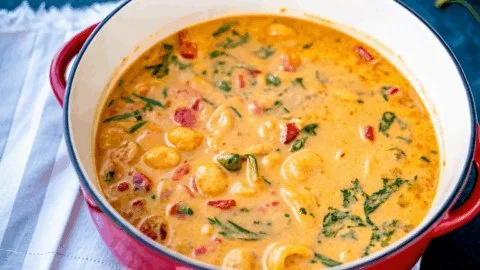Delicious creamy Marry Me Tuscan Chicken Soup served in a bowl with herbs.