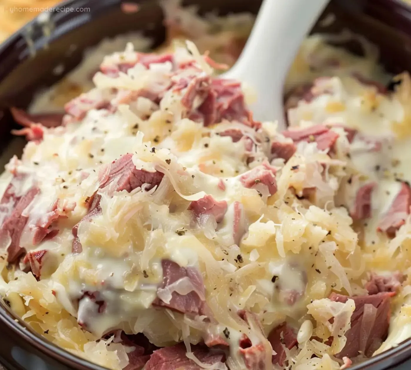 Creamy Reuben Dip served in a bowl with chips and garnished with herbs