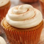 Delicious Pumpkin Spice Cupcakes topped with cream cheese frosting, perfect fall treat.