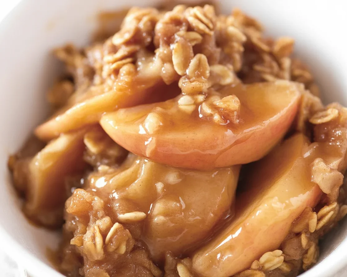 Delicious Apple Crisp with cinnamon apples and brown sugar oat topping, served warm.