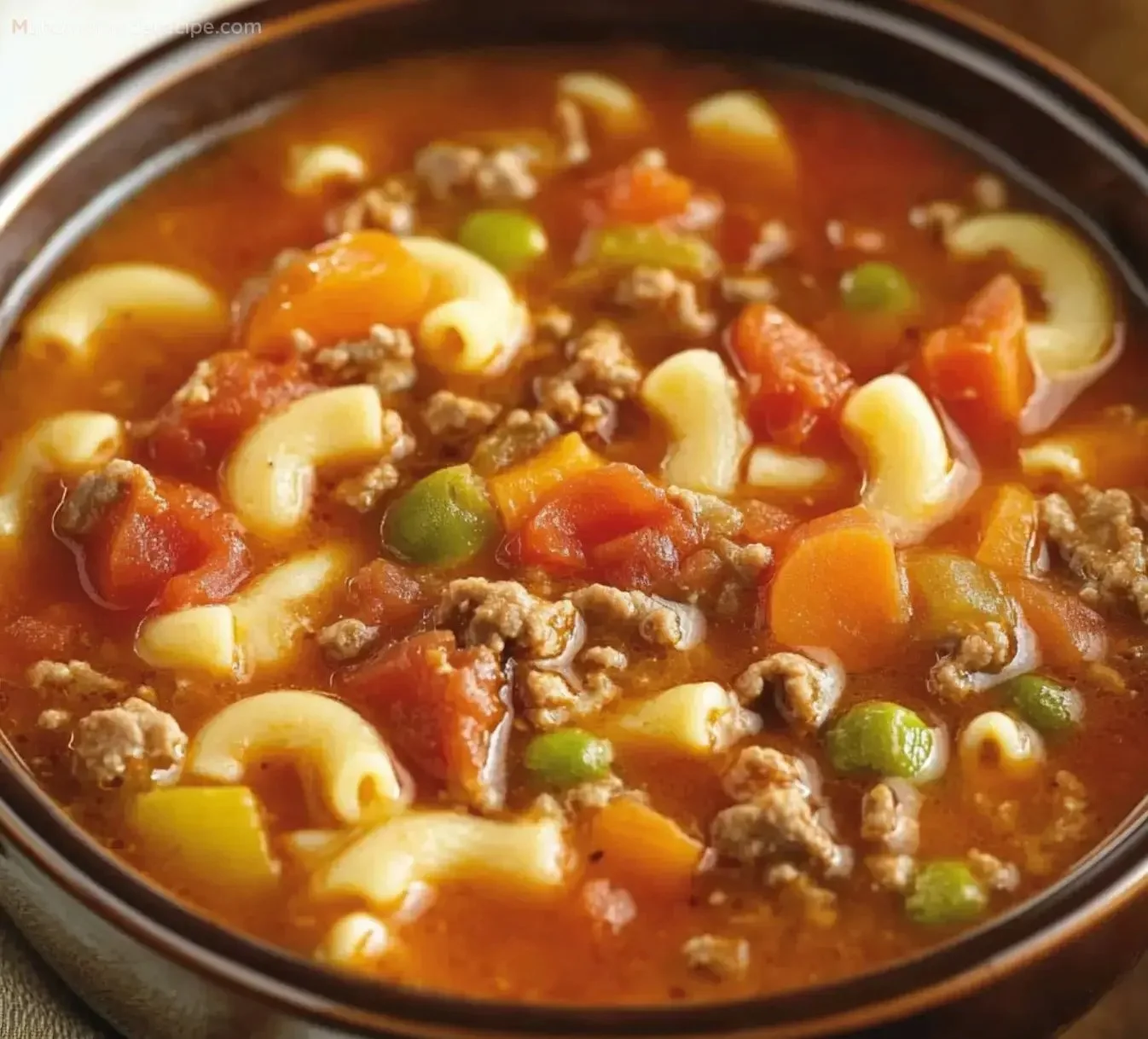 Bowl of Easy Beef and Macaroni Soup garnished with herbs