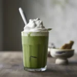 Delicious Matcha latte topped with fluffy whipped cream, perfect for a refreshing drink.