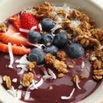 Colorful collagen smoothie bowl topped with fresh fruit and nuts for nutrition.