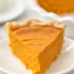 Delicious slice of homemade Sweet Potato Pie with creamy filling and golden crust.