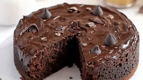 Healthy flourless chocolate cake topped with fresh berries and chocolate drizzle