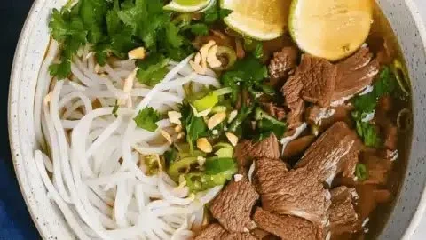 Bowl of savory Instant Pot Pho with herbs and toppings
