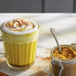 Cup of golden turmeric latte mix with spices and coconut milk