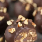 Pecan Pie Truffles coated in chocolate with chopped pecans on top