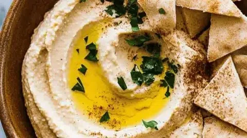 Delicious homemade hummus served with fresh vegetables and pita bread.