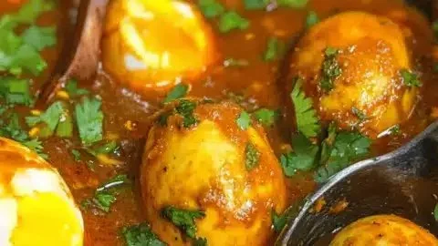 Bowl of Dhaba style masala egg curry garnished with fresh cilantro