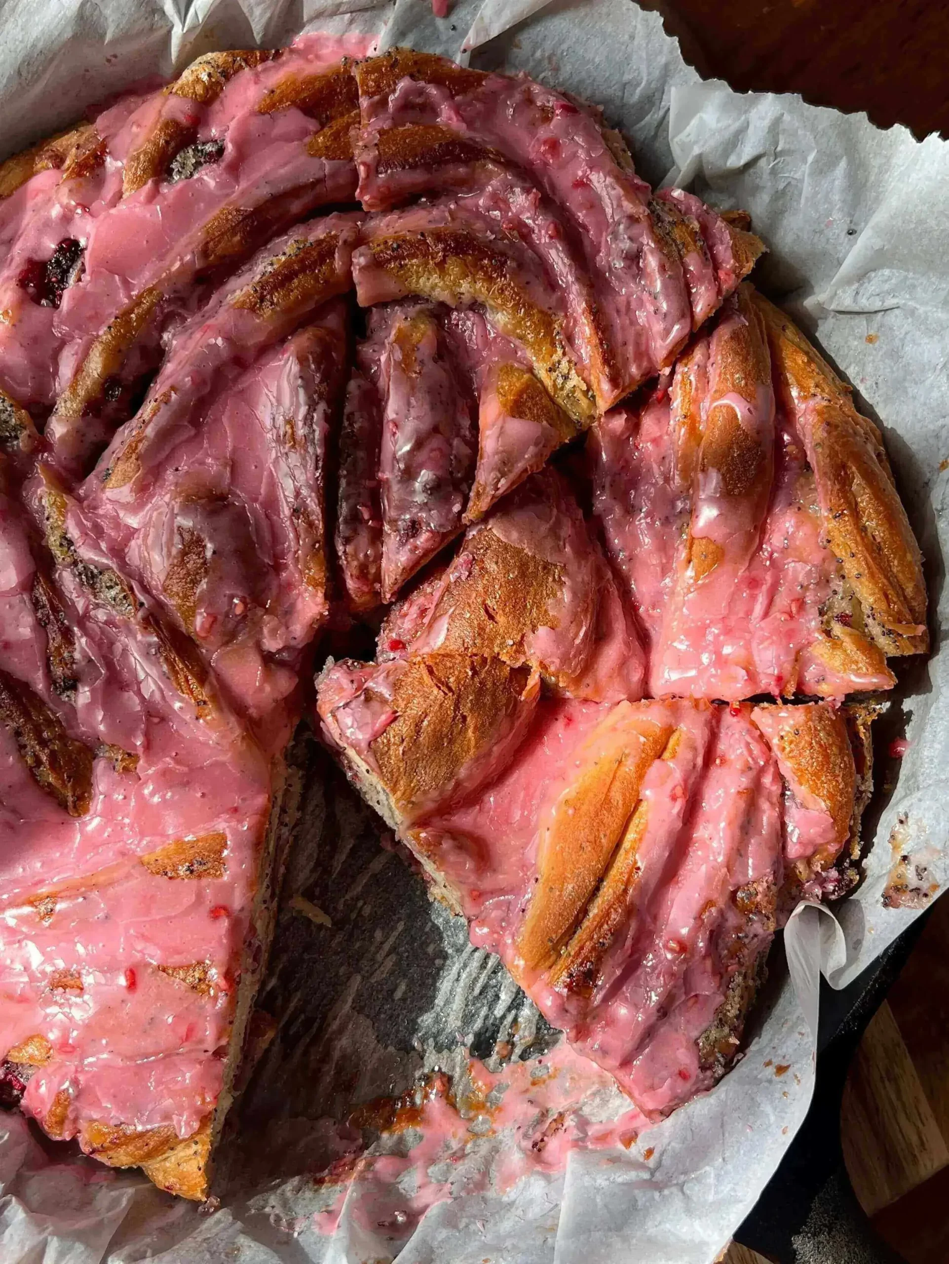 Giant raspberry lemon poppyseed bun on a wooden table, ready to enjoy for breakfast.