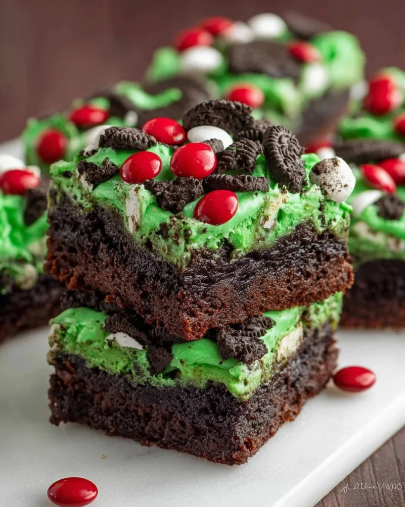 Festively decorated Grinch Brownies with a green topping and red accents
