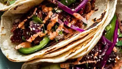Delicious Korean Beef Tacos topped with fresh ingredients in a soft tortilla