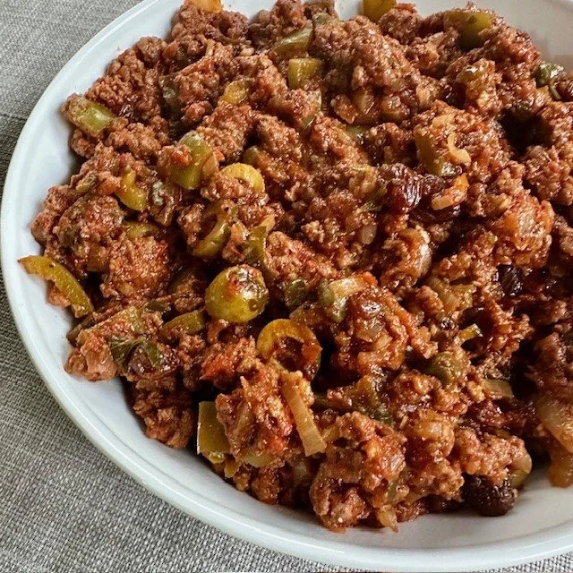 Delicious Cuban Beef Picadillo served with rice and garnished with olives.