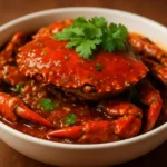 Delicious Singaporean Chilli Crab served with bread and garnished with herbs